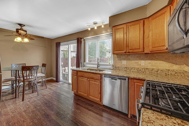 kitchen featuring dark wood-style floors, backsplash, a sink, light stone countertops, and dishwasher