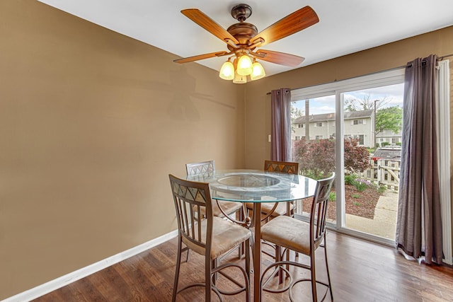 dining space featuring a ceiling fan, baseboards, and wood finished floors