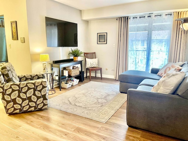 living area with baseboards and wood finished floors