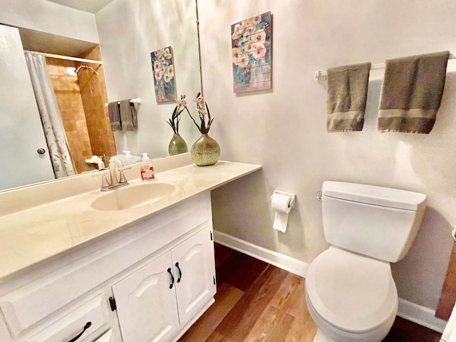 full bathroom featuring baseboards, vanity, toilet, and wood finished floors