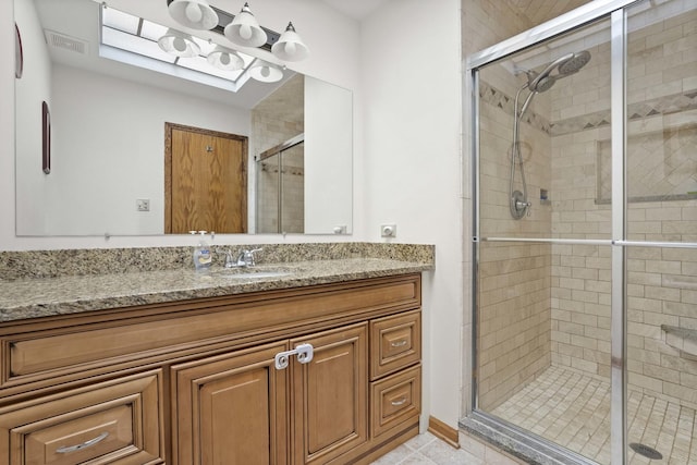 full bathroom featuring a stall shower, visible vents, and vanity