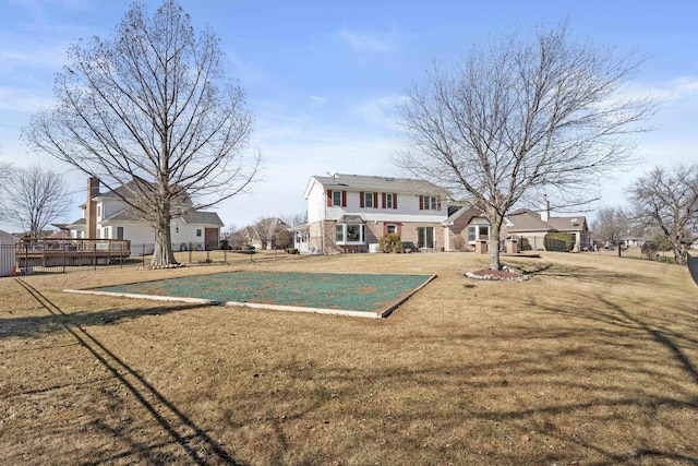 rear view of property featuring fence and a lawn