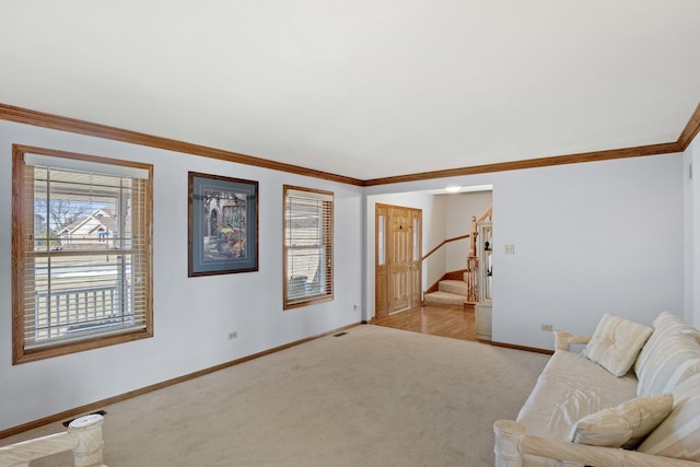 living area with stairs, crown molding, baseboards, and light colored carpet