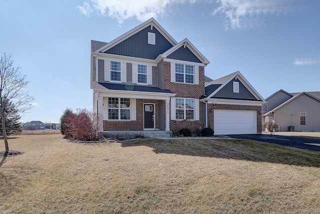 view of front facade featuring aphalt driveway, a garage, brick siding, board and batten siding, and a front yard