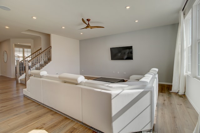 living room featuring light wood-style floors, baseboards, stairway, and recessed lighting