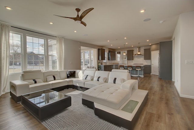 living room featuring a ceiling fan, dark wood-type flooring, and recessed lighting