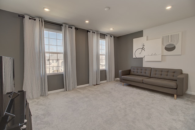 carpeted living area with a healthy amount of sunlight, baseboards, and recessed lighting