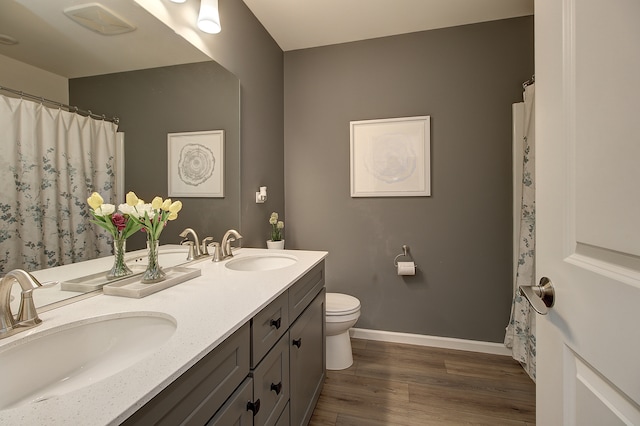 full bath featuring wood finished floors, a sink, toilet, and baseboards