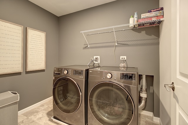 clothes washing area with laundry area, baseboards, and separate washer and dryer