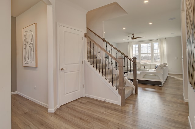 stairway featuring a ceiling fan, baseboards, wood finished floors, and recessed lighting