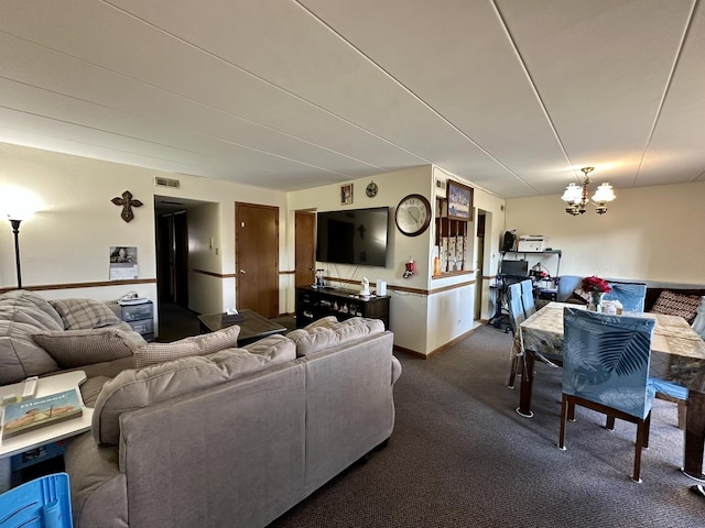 carpeted living room featuring visible vents, baseboards, and an inviting chandelier