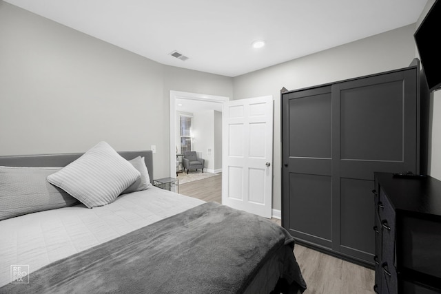 bedroom with light wood-type flooring, baseboards, visible vents, and recessed lighting