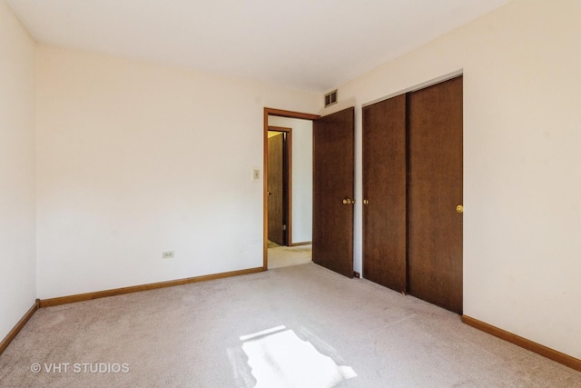 unfurnished bedroom featuring visible vents, baseboards, a closet, and carpet flooring