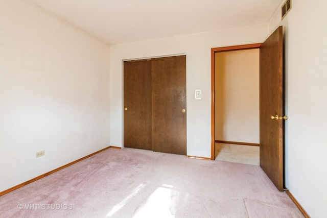 unfurnished bedroom with visible vents, baseboards, carpet, and a closet