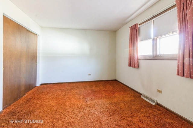 unfurnished room with visible vents, baseboards, and carpet