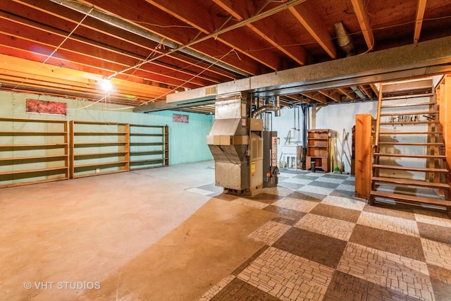 unfinished below grade area featuring heating unit, stairs, and a sink