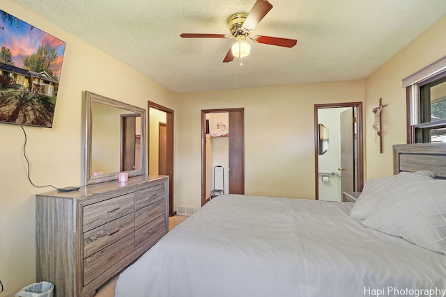 bedroom featuring a textured ceiling, ceiling fan, connected bathroom, and visible vents