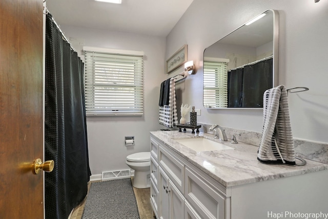 full bath with visible vents, vanity, and toilet