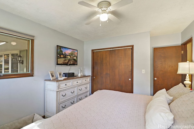 bedroom featuring a textured ceiling, a ceiling fan, and a closet