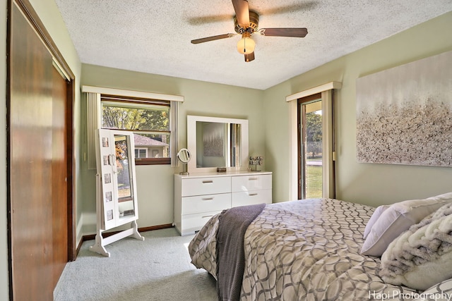 carpeted bedroom with a textured ceiling, access to outside, ceiling fan, and baseboards