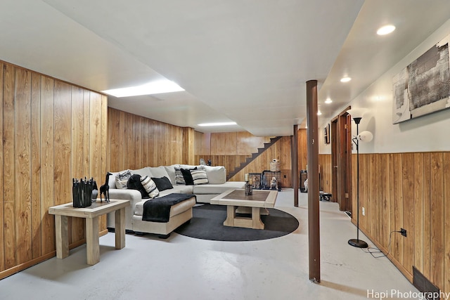 living room featuring stairway, wooden walls, finished concrete floors, and recessed lighting