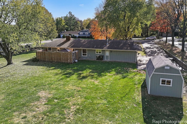 back of house with an outdoor structure and a yard