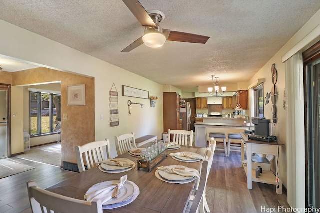 dining room featuring a textured ceiling, hardwood / wood-style floors, and ceiling fan with notable chandelier