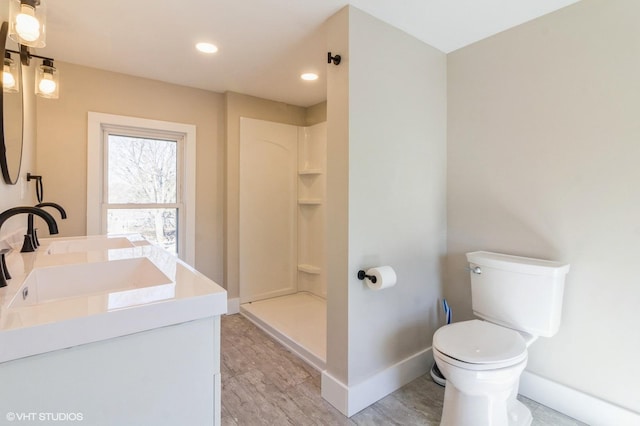 full bath featuring baseboards, vanity, toilet, and a walk in shower