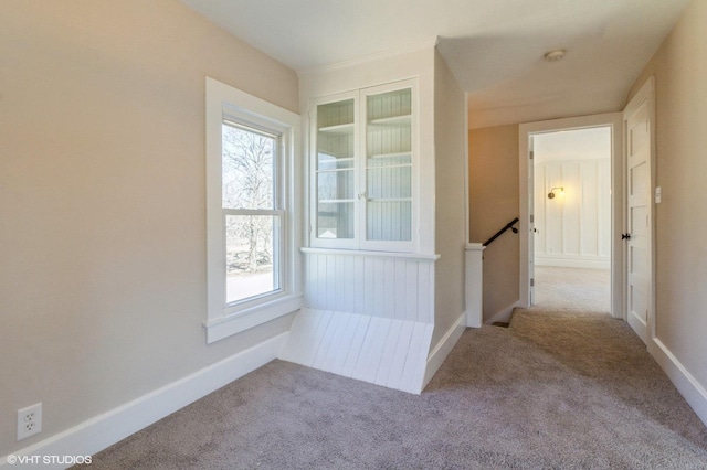 corridor with carpet flooring, an upstairs landing, and baseboards