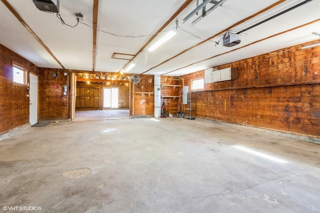 garage featuring a garage door opener and wooden walls