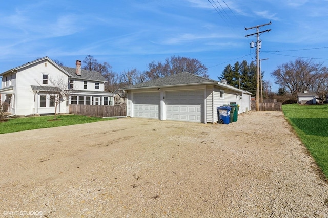 view of front facade with an outdoor structure, fence, and a front yard