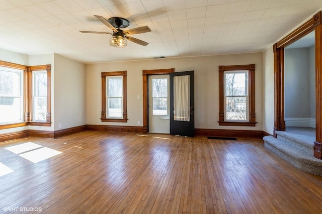 foyer featuring visible vents, ceiling fan, baseboards, and wood finished floors