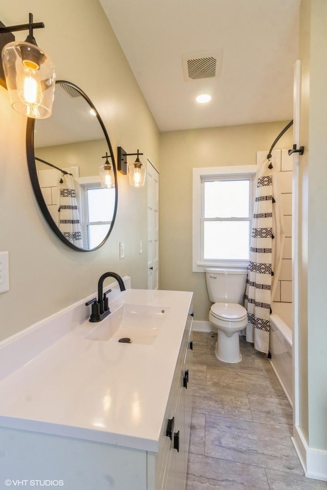 bathroom featuring shower / bath combo, baseboards, visible vents, toilet, and vanity