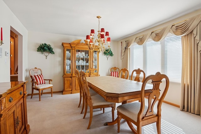 dining room with light carpet, baseboards, and a chandelier