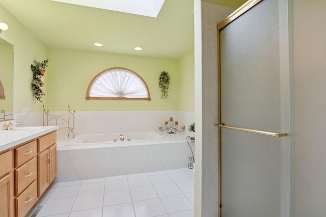 full bath featuring a skylight, a stall shower, tile patterned floors, a garden tub, and vanity