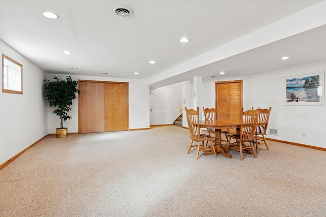 dining area with light carpet, visible vents, stairway, and baseboards