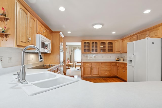 kitchen featuring light countertops, white appliances, open shelves, and glass insert cabinets