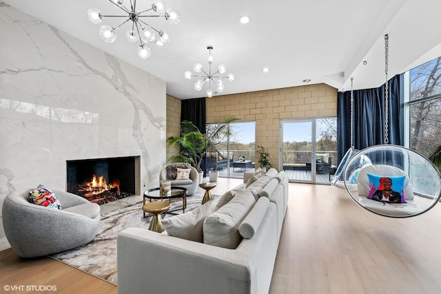 living area featuring a chandelier, recessed lighting, wood finished floors, and a premium fireplace