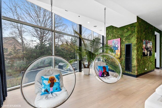 interior space with expansive windows, wood finished floors, and recessed lighting