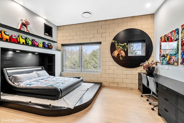 bedroom featuring recessed lighting, built in study area, and wood finished floors