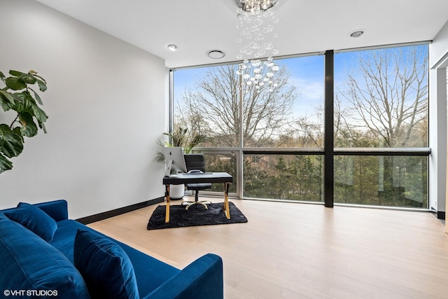 interior space with a wealth of natural light, expansive windows, a chandelier, and wood finished floors