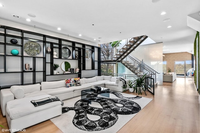 living room with recessed lighting, stairway, and wood finished floors