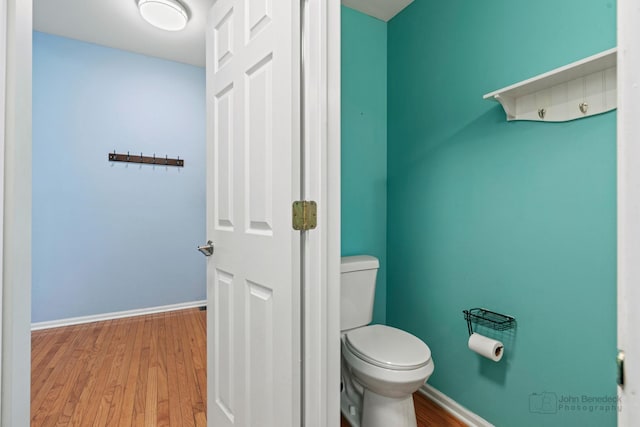 bathroom featuring wood finished floors, toilet, and baseboards