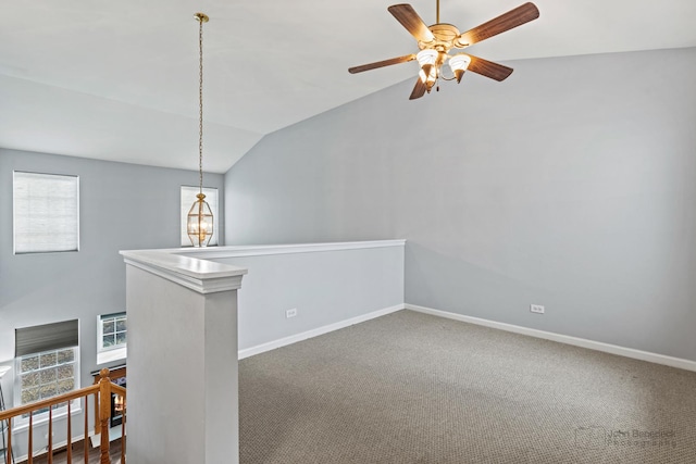 unfurnished room with carpet, baseboards, vaulted ceiling, and ceiling fan with notable chandelier