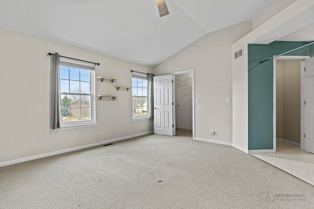 unfurnished bedroom featuring carpet floors, visible vents, baseboards, vaulted ceiling, and a spacious closet