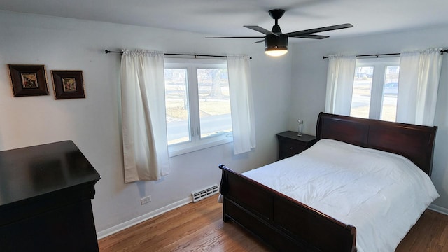 bedroom featuring ceiling fan, baseboards, and wood finished floors