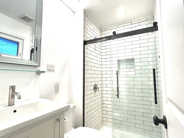 full bath with toilet, vanity, a shower stall, and visible vents