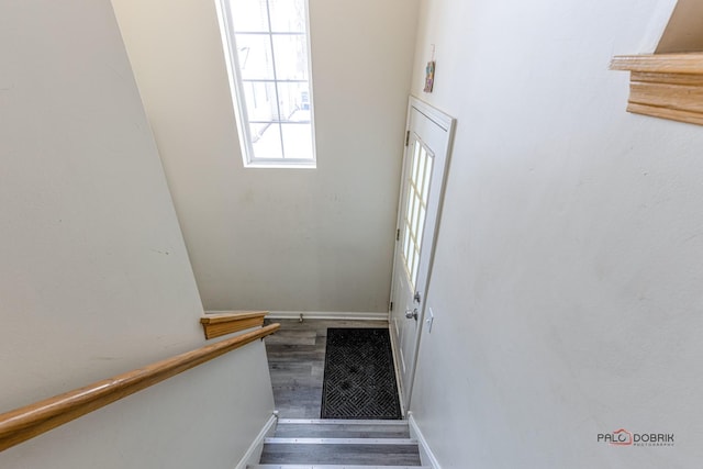 stairway with wood finished floors and baseboards