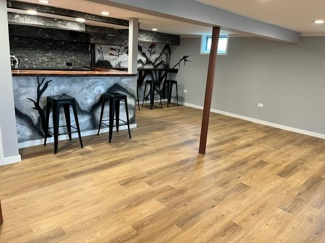 bar with a dry bar, baseboards, wood finished floors, and recessed lighting