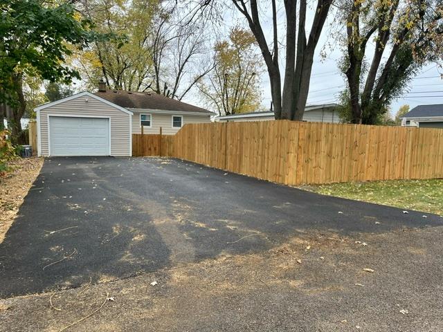 exterior space with a garage, driveway, and fence